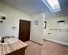 Bathroom featuring a wealth of natural light, tile patterned floors, lofted ceiling with skylight, and vanity