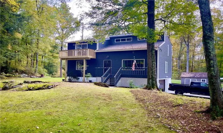 Front view of house with a balcony, front porch and a lawn