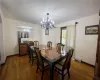 Dining space with a baseboard heating unit, wood-type flooring, and an inviting chandelier