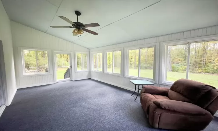 Sunroom / solarium with ceiling fan, lofted ceiling, and a wealth of natural light