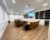 Living room with built in features, bar area, wine cooler, and light hardwood / wood-style flooring