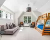 Carpeted bedroom featuring lofted ceiling and multiple windows