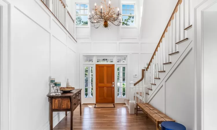 Entryway with dark hardwood / wood-style floors, a high ceiling, and an inviting chandelier