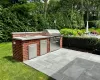 View of patio with a grill, sink, and exterior kitchen