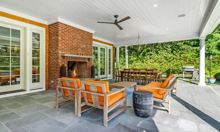 View of patio / terrace with an outdoor living space with a fireplace, grilling area, and ceiling fan