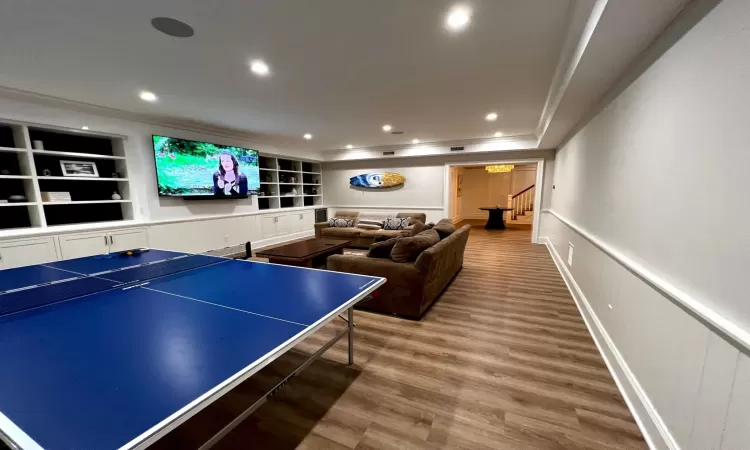 Game room with hardwood / wood-style floors and built in features