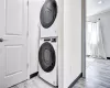 Laundry room featuring light hardwood / wood-style floors and stacked washer / drying machine