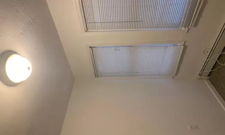 Spare room featuring baseboard heating, a textured ceiling, and dark colored carpet