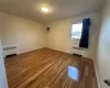 Bedroom room with a wall unit AC, radiator, and dark hardwood / wood-style floors