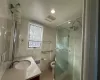 Downstairs Bathroom featuring an enclosed shower, radiator heating unit, vanity, and tile walls