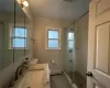 Upstairs Bathroom with toilet, vanity, an enclosed shower, and a baseboard heating unit