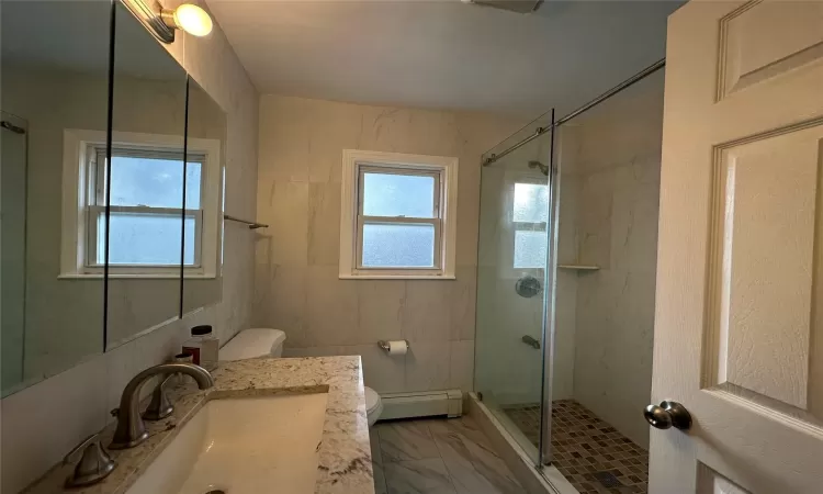 Upstairs Bathroom with toilet, vanity, an enclosed shower, and a baseboard heating unit