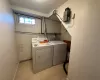 Clothes washing area with washer and dryer and light wood-type flooring