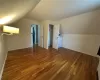 Bonus room featuring dark hardwood / wood-style flooring and lofted ceiling