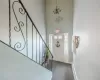 Carpeted foyer with baseboard heating, a towering ceiling, and a notable chandelier