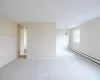 Carpeted empty room with an inviting chandelier and a baseboard radiator