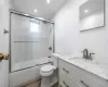 Full bathroom featuring shower / bath combination with glass door, vanity, and toilet