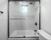 Bathroom featuring toilet and combined bath / shower with glass door