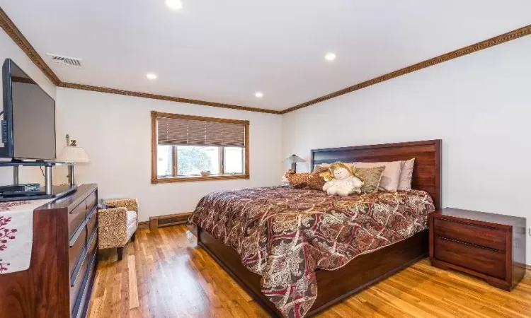 Bedroom featuring light hardwood / wood-style flooring and ornamental molding