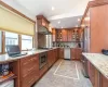 Kitchen featuring backsplash, light stone counters, and stainless steel appliances