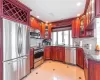 Kitchen with decorative backsplash, appliances with stainless steel finishes, dark stone counters, sink, and light tile patterned floors