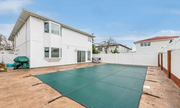 Rear view of house featuring a patio and a covered pool