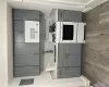 Kitchen featuring gray cabinets, white appliances, and sink