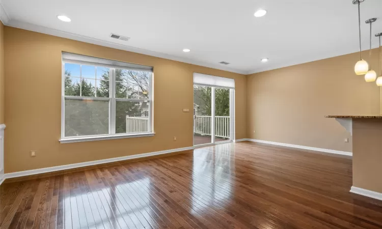 Kitchen with appliances with stainless steel finishes, light stone counters, crown molding, and sink