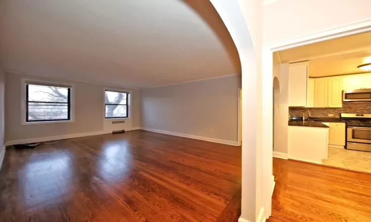 Unfurnished living room featuring light hardwood / wood-style floors and sink