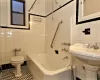 Bathroom featuring tile patterned floors, tiled shower / bath, tile walls, and toilet