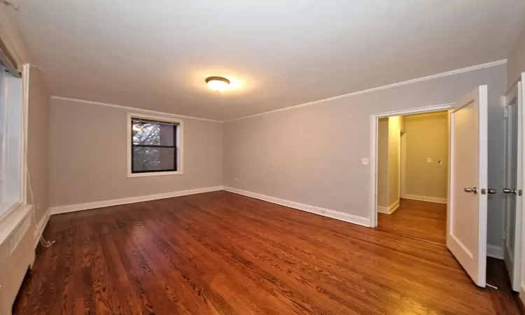 Unfurnished room with ornamental molding and hardwood / wood-style flooring