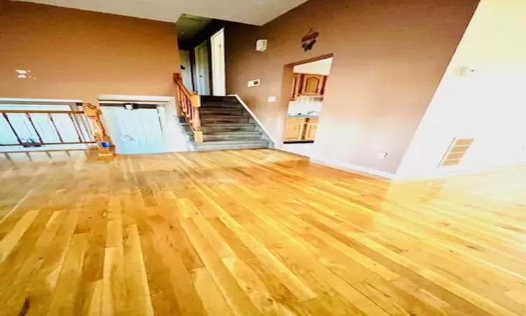 living room with light hardwood / wood-style floors and a high ceiling