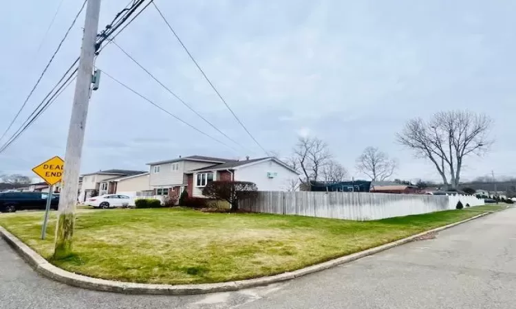 View of side of home featuring a lawn and a water view