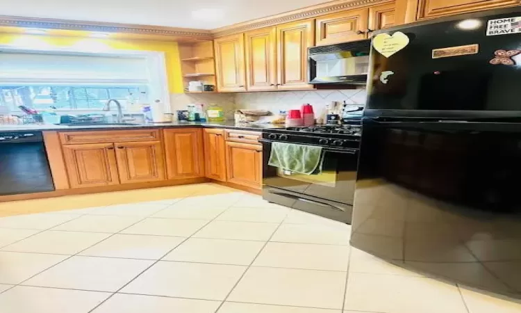 Kitchen with light tile patterned flooring, sink, tasteful backsplash, and black appliances