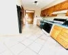 Kitchen featuring decorative backsplash, sink, light tile patterned flooring, and black appliances