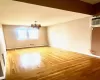 Dining area featuring hardwood  flooring, a wall mounted air conditioner, and an inviting chandelier