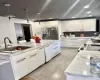 Kitchen with sink, white cabinets, decorative light fixtures, and stainless steel refrigerator with ice dispenser