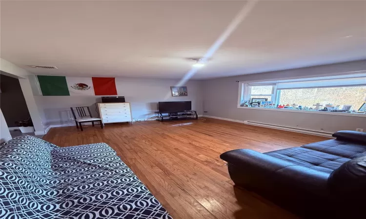 Living room featuring a baseboard radiator and hardwood / wood-style flooring