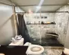 Bathroom featuring a shower with shower curtain and toilet