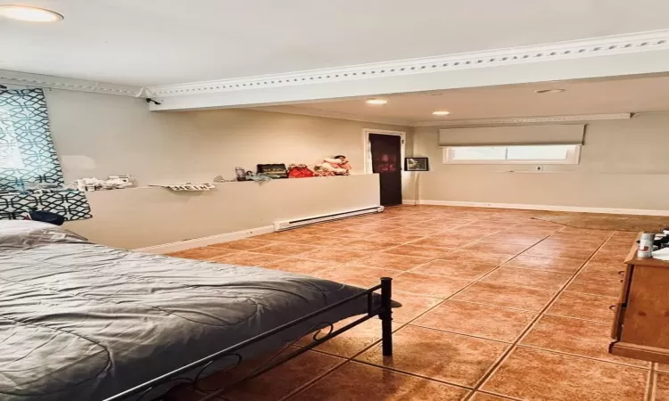 Bedroom featuring crown molding, tile patterned flooring, and a baseboard radiator