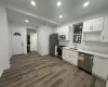 Kitchen with white cabinets, sink, dark hardwood / wood-style flooring, and stainless steel appliances