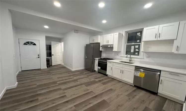 Kitchen with white cabinets, sink, dark hardwood / wood-style flooring, and stainless steel appliances