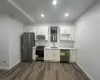 Kitchen featuring white cabinets, dark hardwood / wood-style flooring, sink, and appliances with stainless steel finishes