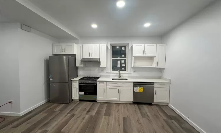 Kitchen featuring white cabinets, dark hardwood / wood-style flooring, sink, and appliances with stainless steel finishes