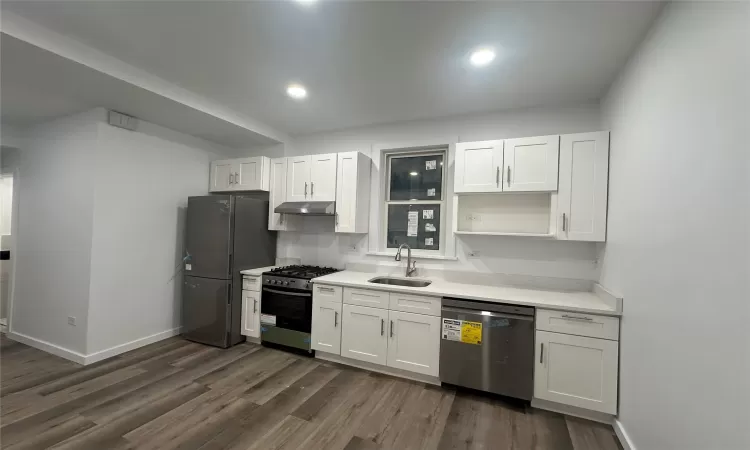 Kitchen featuring dark hardwood / wood-style flooring, stainless steel appliances, white cabinetry, and sink