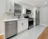 Kitchen with appliances with stainless steel finishes, tasteful backsplash, white cabinetry, and sink