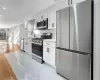 Kitchen with plenty of natural light, sink, white cabinetry, and stainless steel appliances