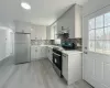 Kitchen with white cabinets, light wood-type flooring, sink, and appliances with stainless steel finishes