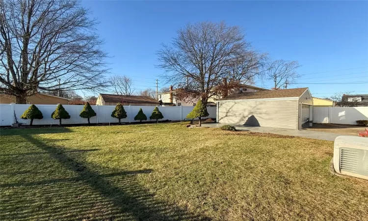 View of yard with a garage and an outdoor structure