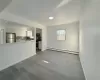 Unfurnished living room with sink, light wood-type flooring, and a baseboard heating unit